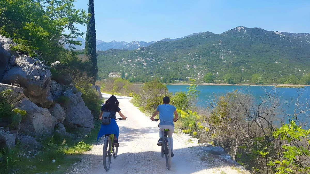 Cyclist exploring Baćina Lakes in southern Dalmatia, Croatia, riding around scenic freshwater lakes surrounded by hills, villages, and Adriatic views – Cycling Croatia Dubrovnik region