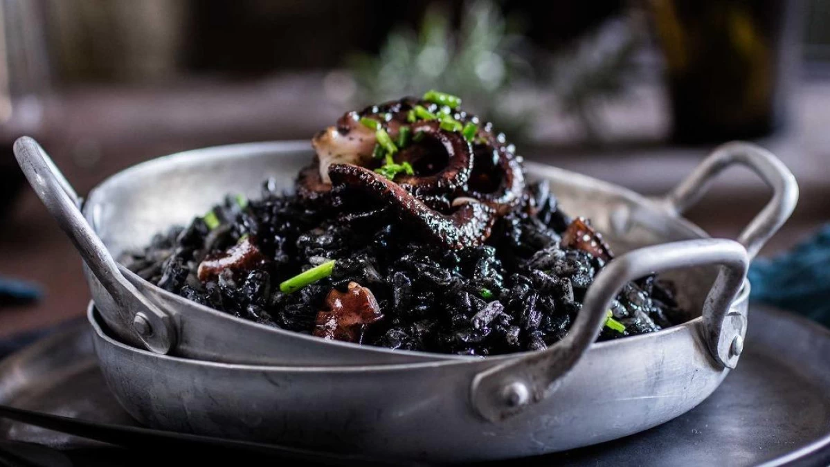 Traditional Croatian food black risotto, Dalmatian seafood dish made with cuttlefish, squid ink, rice, and Mediterranean spices