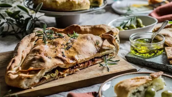 Traditional Croatian food Komiška pogača, savory pie from Vis island filled with salted fish, onions, and Mediterranean flavors.