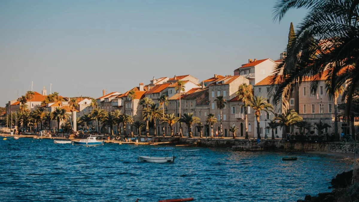 Aerial view of Korčula Old Town, Croatia, with medieval stone walls, red rooftops, and the surrounding blue Adriatic Sea.