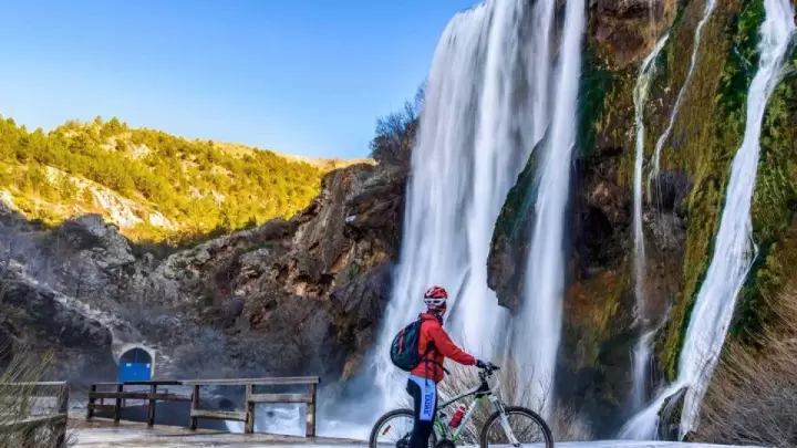 Cyclist exploring Krka National Park in Croatia, riding along trails next to the famous waterfalls surrounded by lush greenery – Cycling Croatia Šibenik region